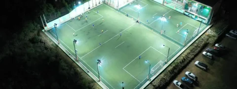 Vista aérea de campo de futebol society iluminado à noite